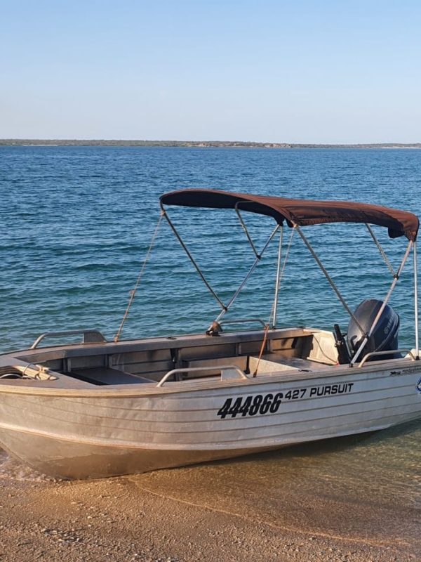 A dinghy sits on the shore of Cygnet Bay, ready to be hired and used by guests staying at our Cygnet Bay Pearl Farm for fishing or to enjoy a secret beach trip.