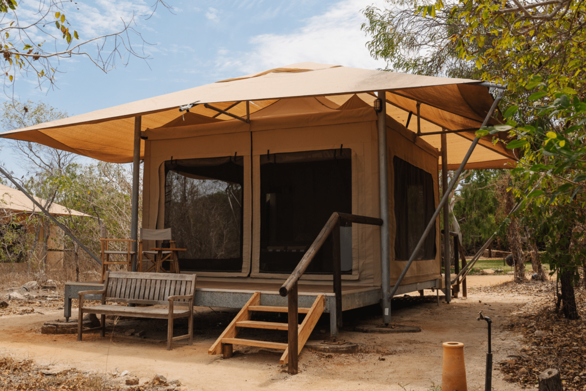 The Bayview Safari Tent Beds side by side in the tent, with a wall fan in the corner to keep cool. In the distance is the blue waters of Cygnet Bay, only a short walk away.