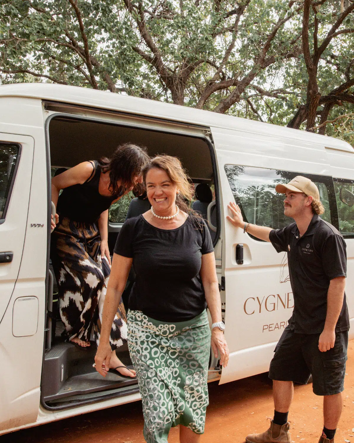 Guests getting off the Cygnet Bay transfer bus, ready to begin their adventure at Cygnet Bay Pearl Farm with smiles on their faces.