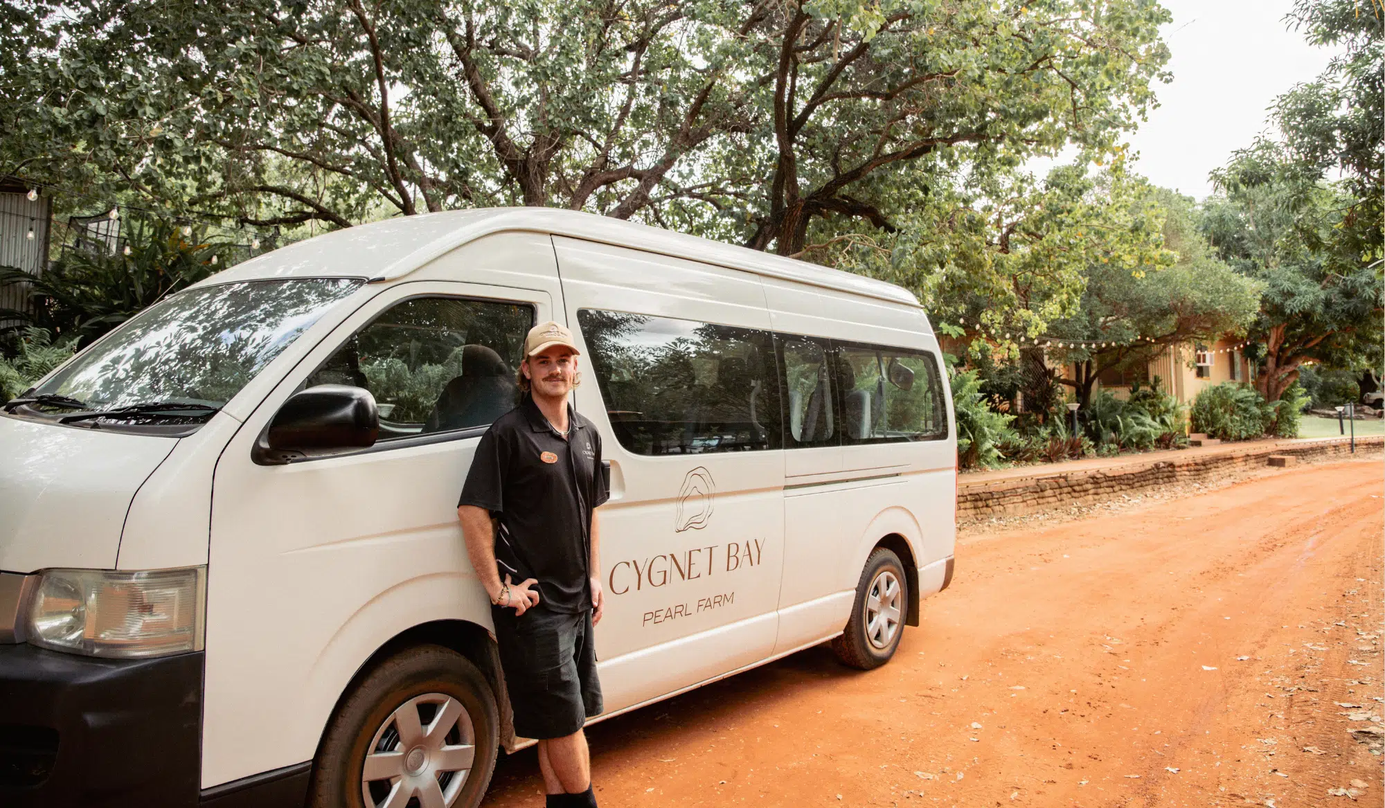 Bus driver standing next to Cygnet Bay Pearl Farm bus transfers.