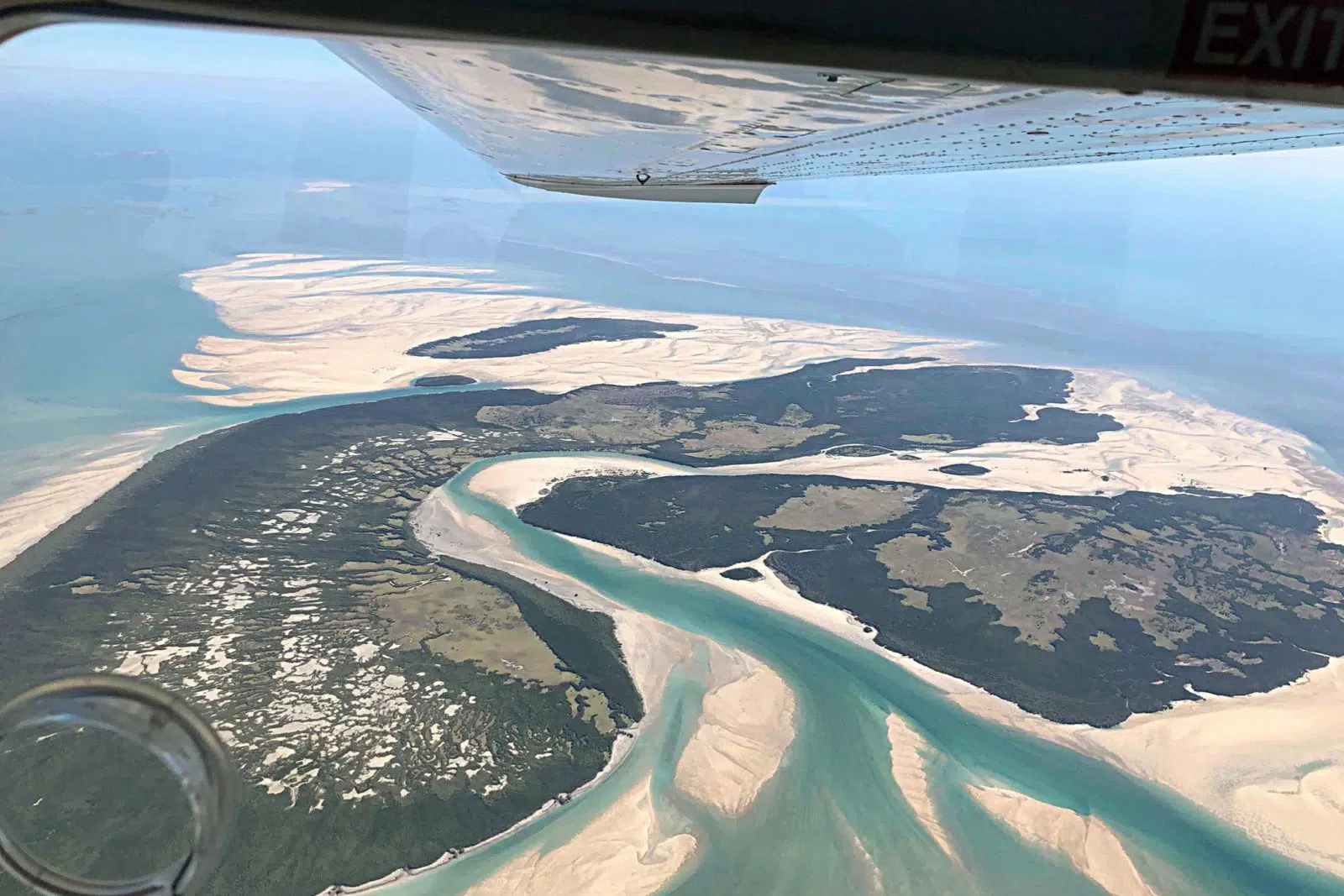 An aerial photo from an airplane of the stunning landscape that is the Kimberley and the Buccaneer Archipelago - white sands, surrounded by still blue waters.