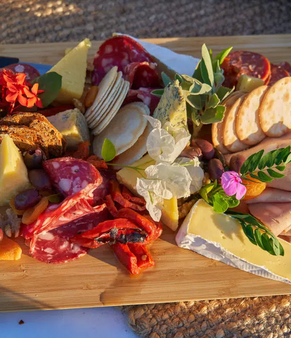 A charcuterie board with cold cut meats, soft cheeses, nuts, and crackers for guests to enjoy. Our Dining.