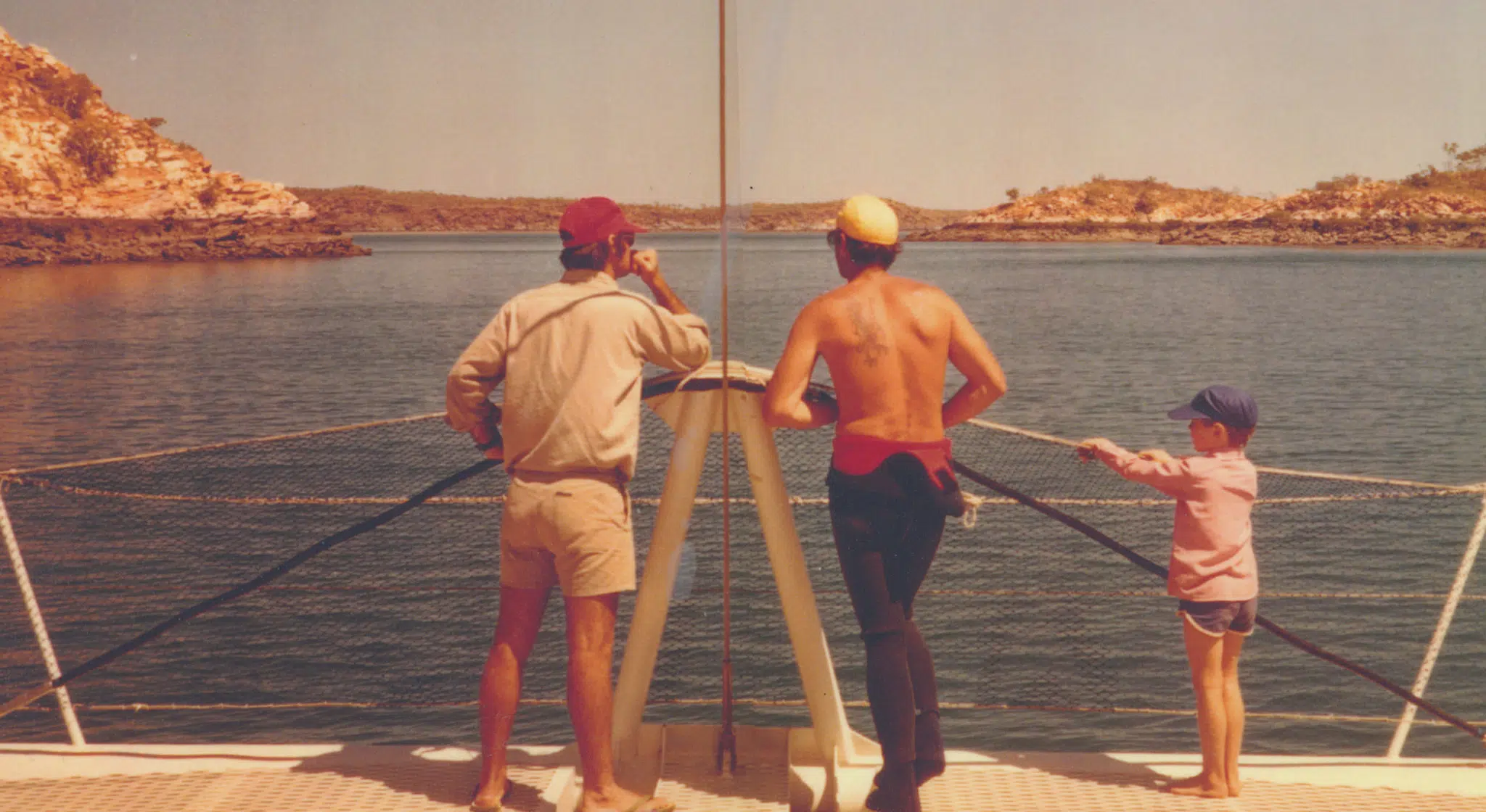 A historical image of the Brown family standing on a pearling boat, overlooking Cygnet Bay. Just like today, the waters are turquoise and clear, and the landscape is burnt orange.