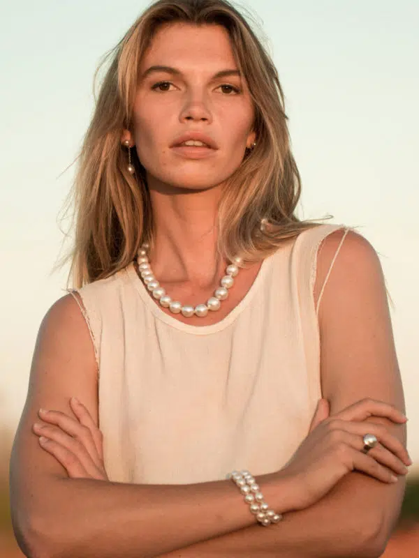 A model wears the Classics Pearl Jewellery Collection while enjoying the beautiful Kimberley sunset. She wears a pair of Provenance Earrings, a South Sea pearl strand neckalce, a South Sea pearl strand bracelet, and a Save the Children Mabe pearl ring. All featured pearls are Australian South Sea pearls locally grown at our Cygnet Bay Pearl Farm.