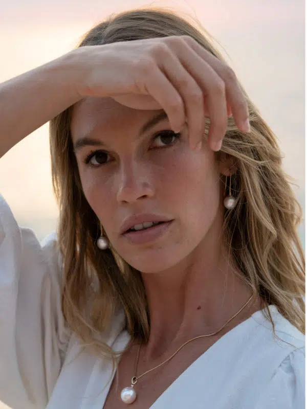 A model wears the Classics Pearl Jewellery Collection while enjoying the beautiful Kimberley sunrise. She wears a pair of Inca hooks and a pendant hung on a snake chain. All featured pearls are Australian South Sea pearls locally grown at our Cygnet Bay Pearl Farm.