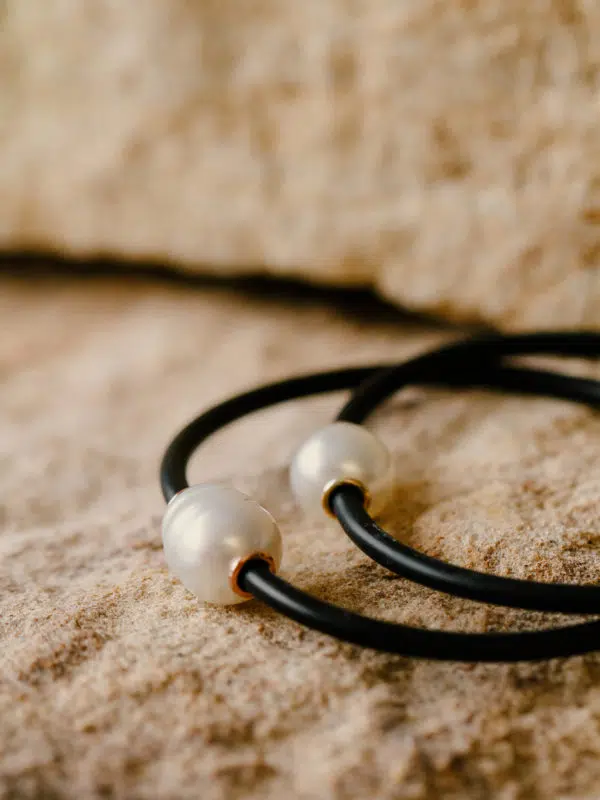 Two Neoprene Bracelets sit on sandstone. They feature an Australian South Sea Circle pearl, grown at our very own Cygnet Bay Pearl Farm, with two 9ct gold rondels on either side of the pearls.